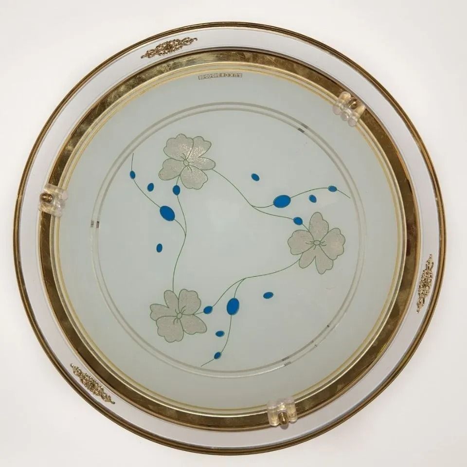 Lampada da soffitto circolare con finiture dorate e vetro satinato. Motivo floreale al centro con accenti blu.