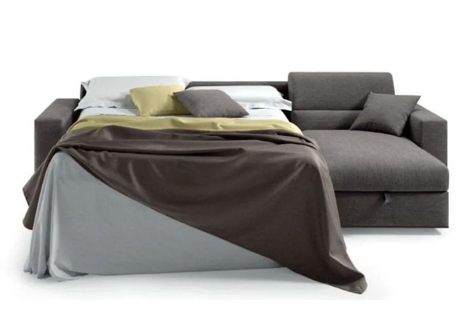 Divano componibile grigio con letto estraibile, biancheria da letto a vista.