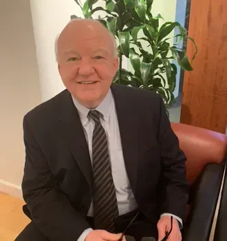 A man in a suit and tie is sitting in a chair