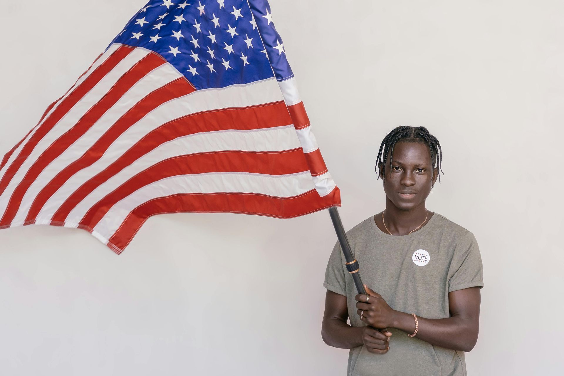 A man wearing headphones is holding an american flag.