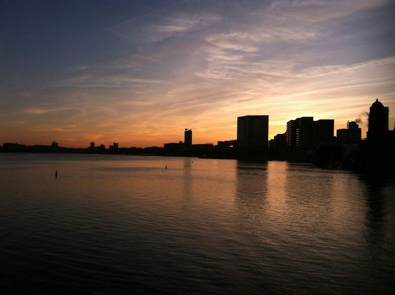 A sunset over a body of water with a city in the background