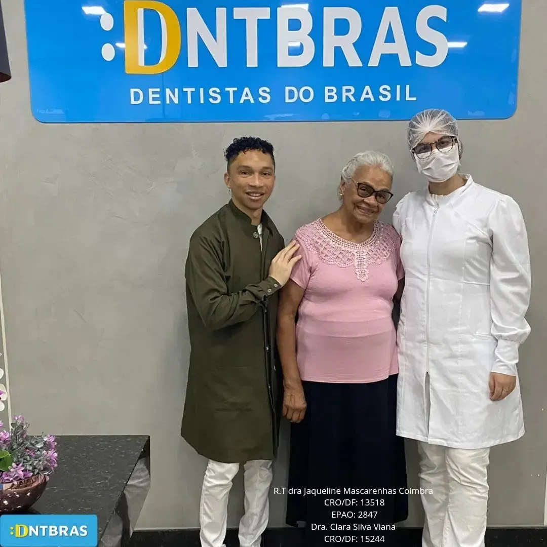 um grupo de pessoas em frente a uma placa que diz dentistas do brasil