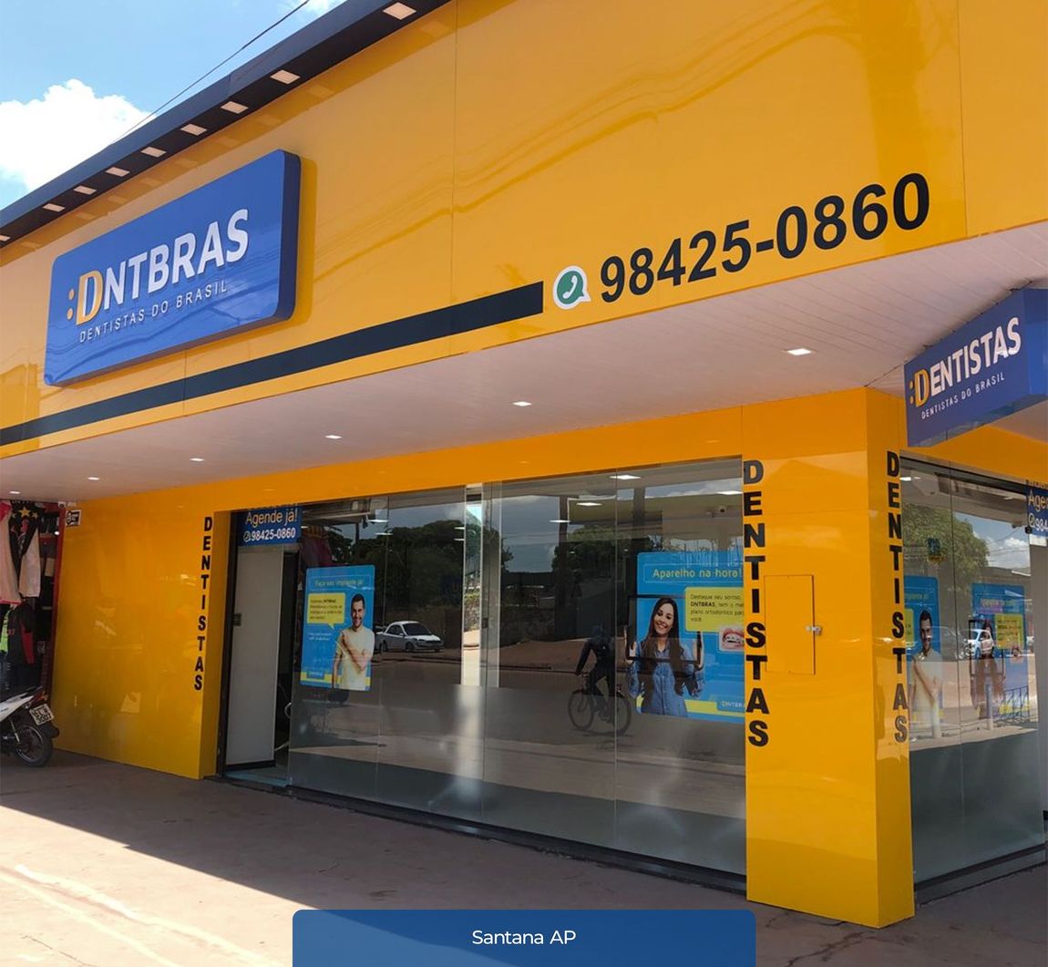 um prédio amarelo com uma placa azul que diz dentistas