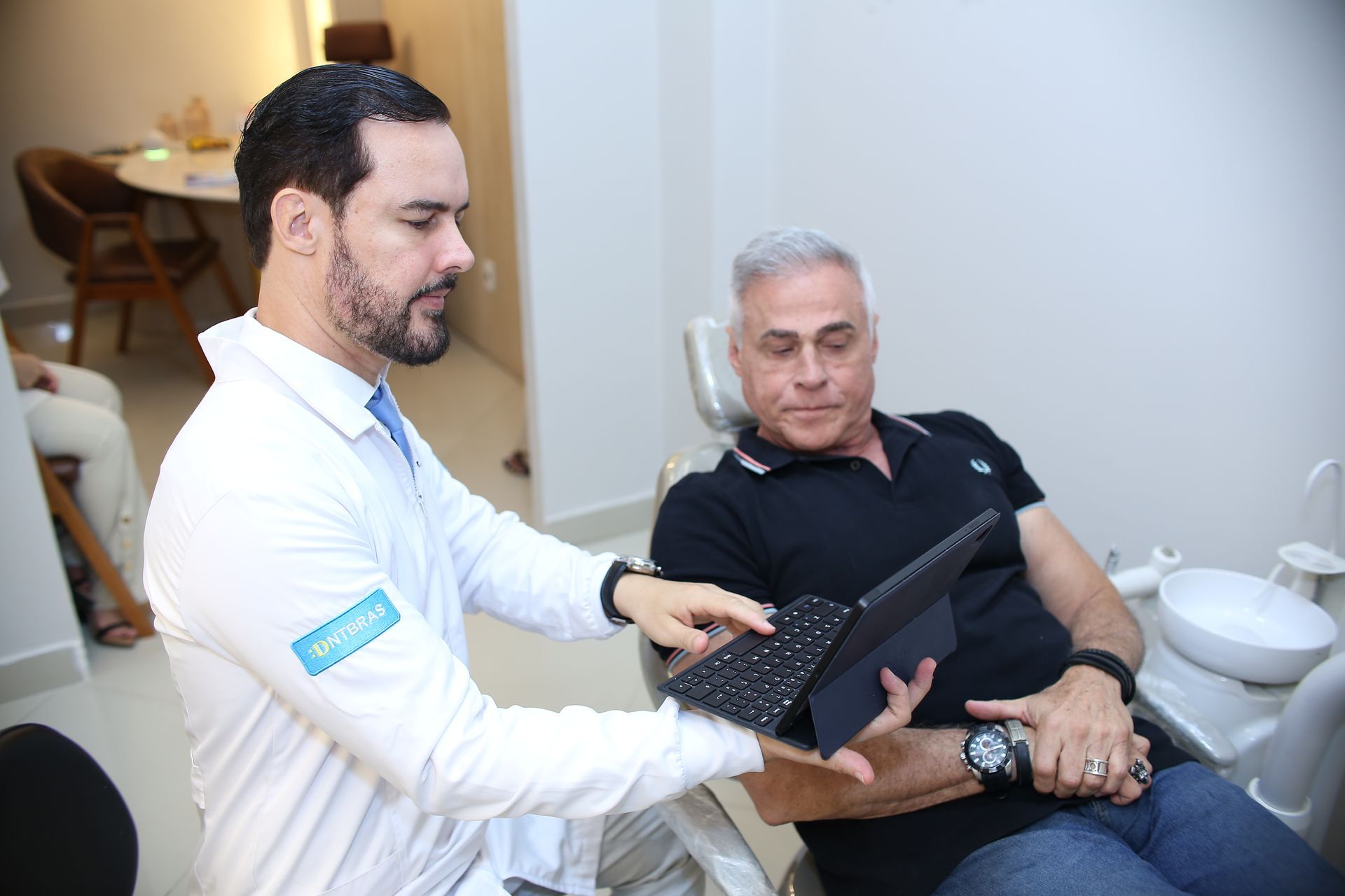 um jovem de camisa azul está sorrindo para a câmera.