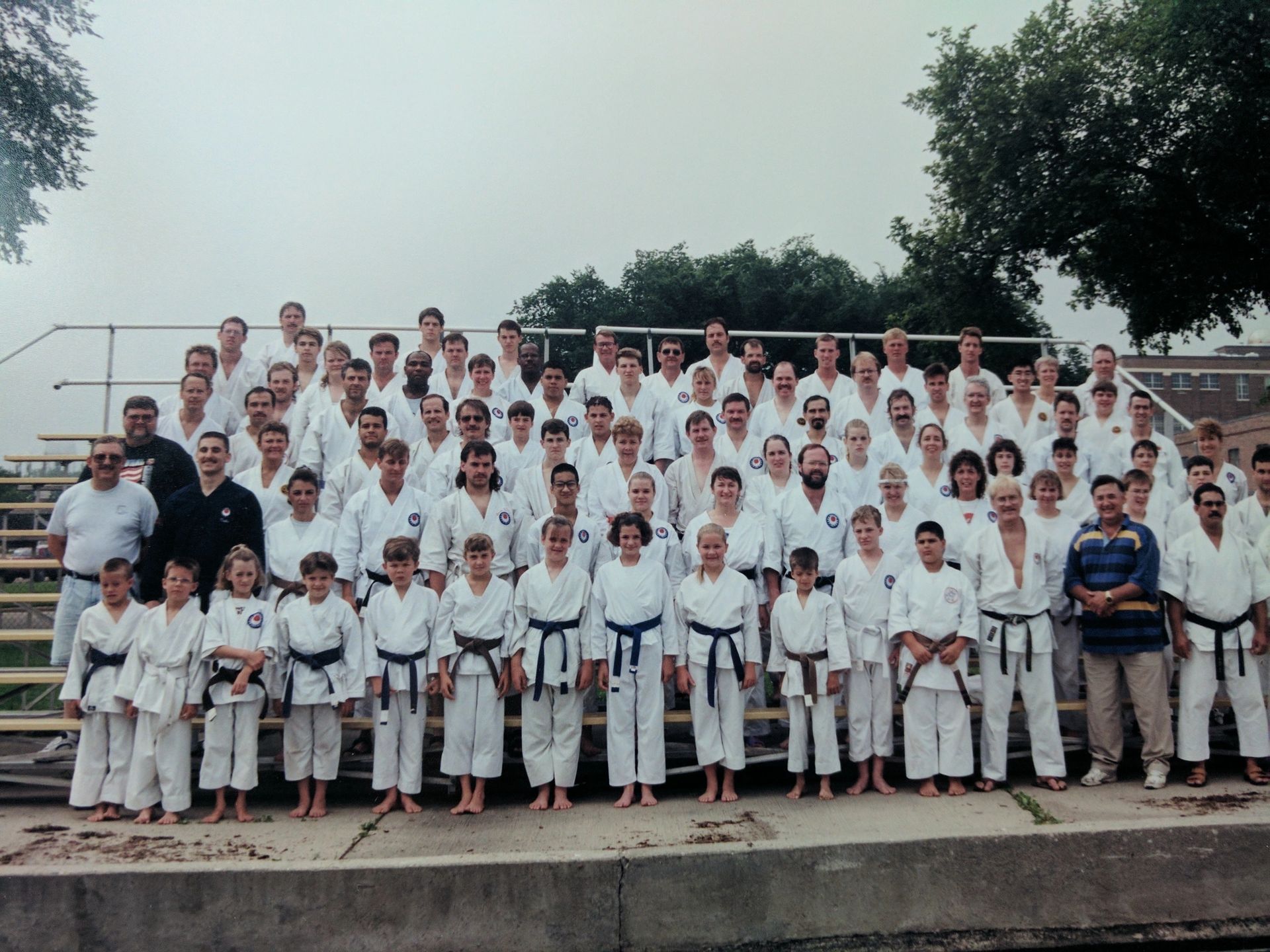 A large group of people in karate uniforms pose for a photo
