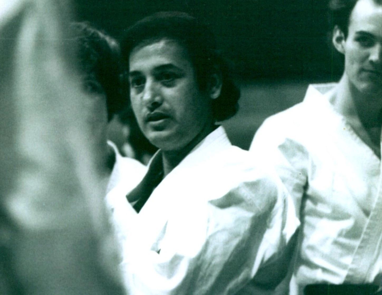 A black and white photo of a man in a karate uniform