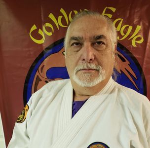 A man standing in front of a golden eagle banner