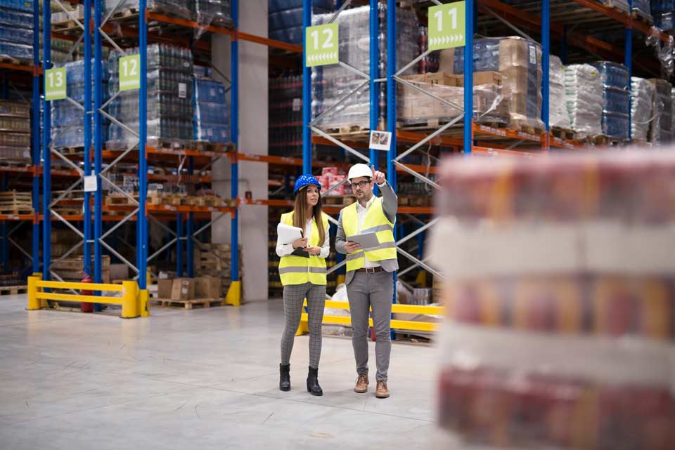 two people in visibility vests in storage facility
