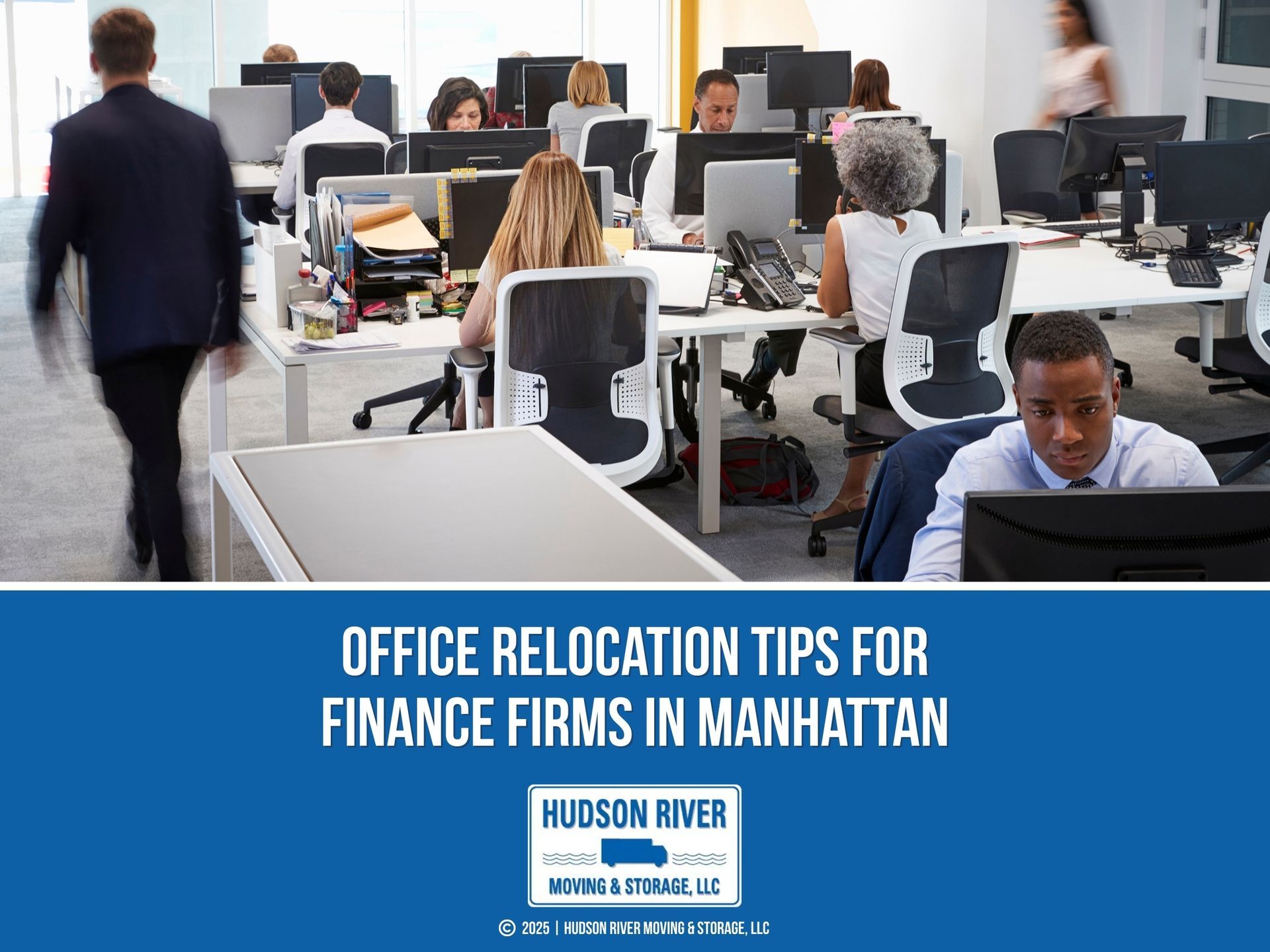 People work and move around in a busy open-plan office filled with desks, computers.