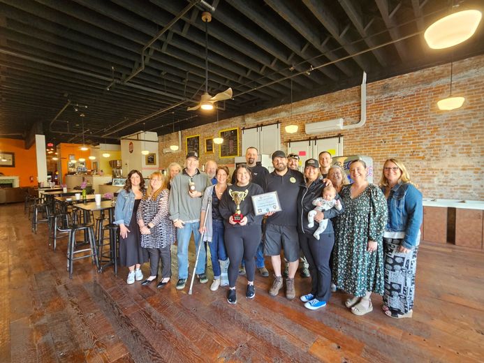 A group of people are posing for a picture in a restaurant.