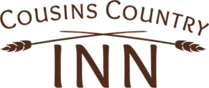 A logo for cousins country inn with two crossed arrows