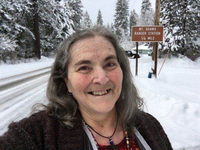 A woman is smiling in front of a sign that says ranger station