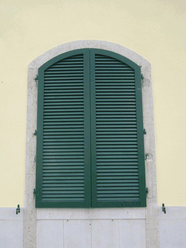 finestra ad arco con persiana verde chiusa