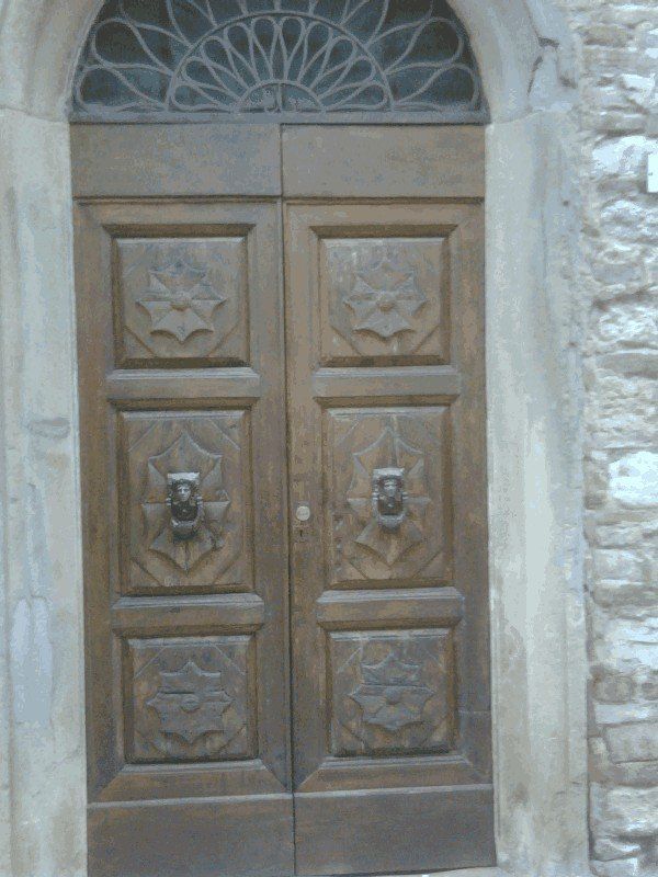 portone d'ingresso in legno con decorazioni restaurato