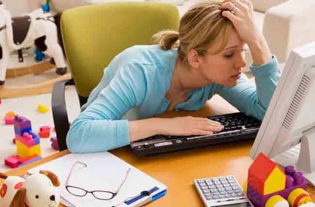 A woman is sitting at a desk using a computer.