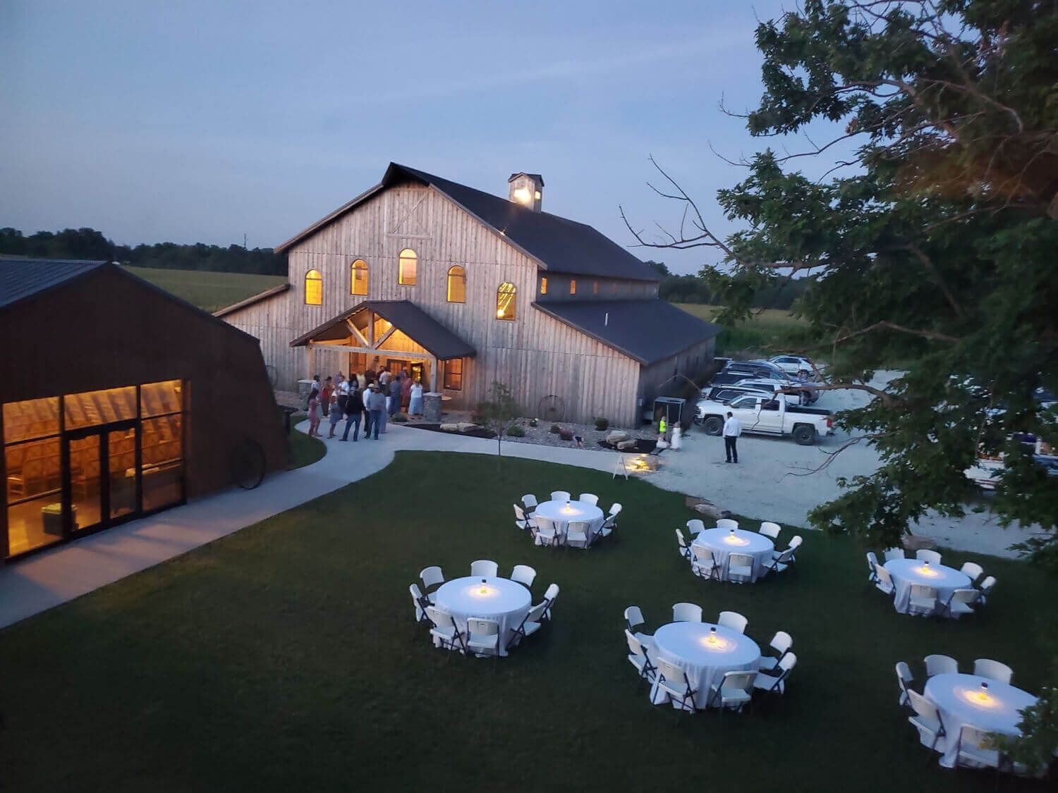 Barn event venue with round tables on the lawn