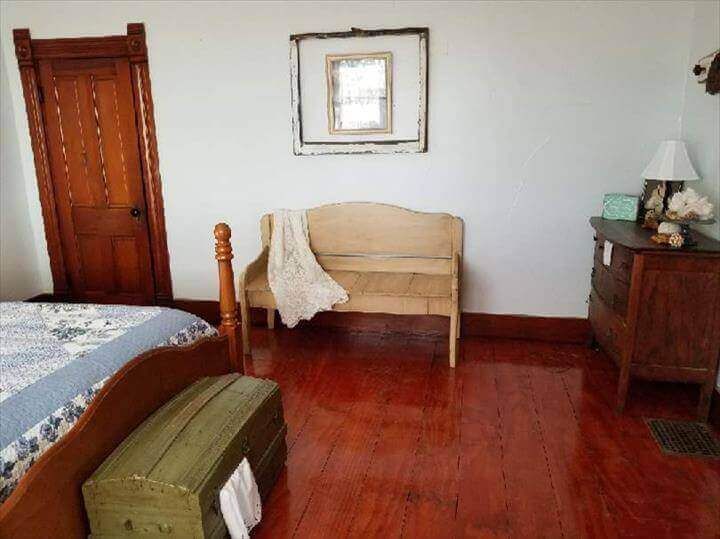 Bedroom with hardwood floors, wooden furniture, and a distressed mirror.