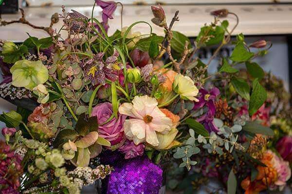 Close-up of a floral arrangement with pink, purple, and green blooms.
