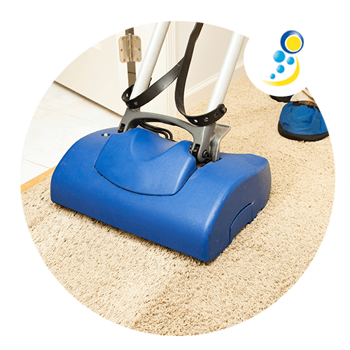 Una aspiradora azul está limpiando una alfombra en una habitación.