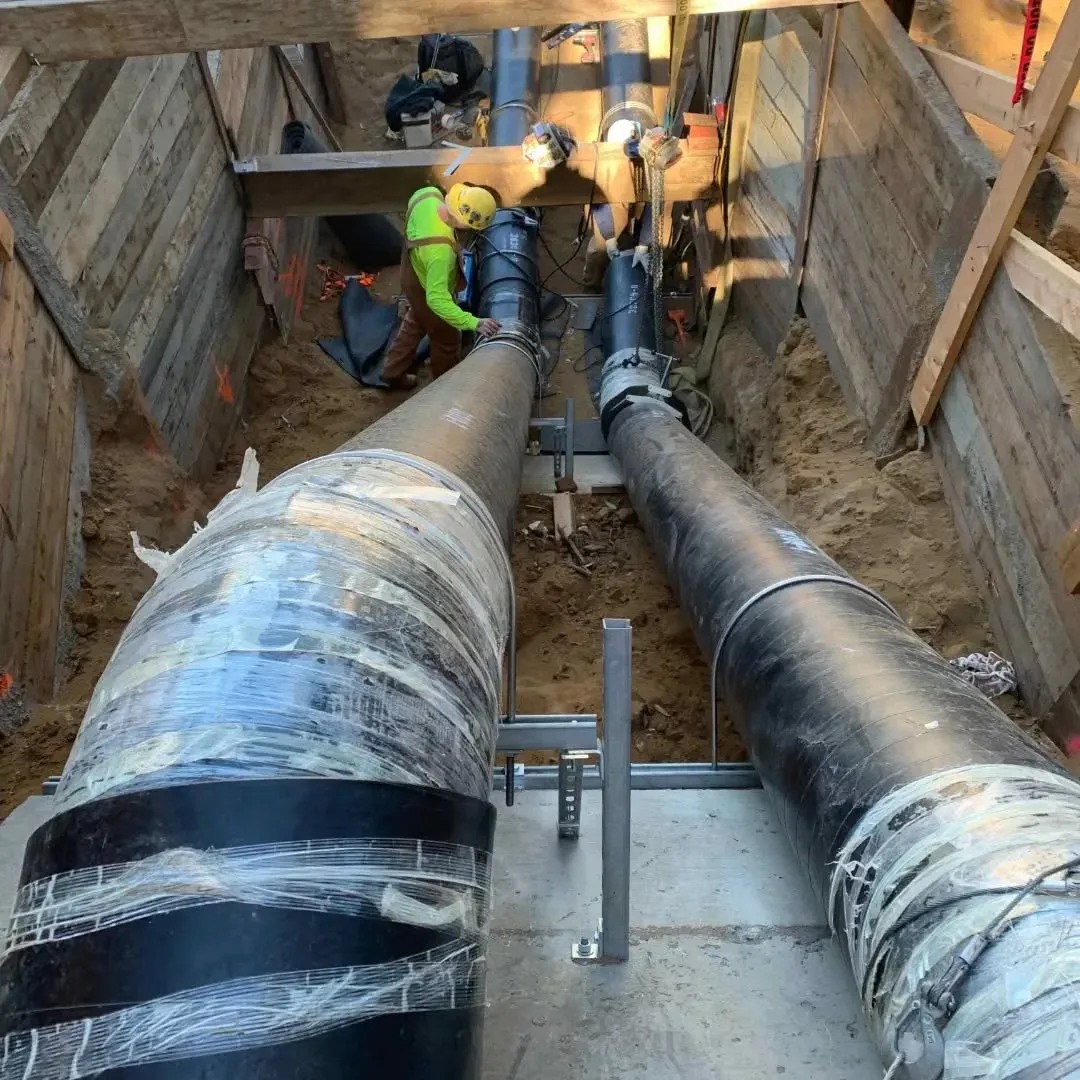 A man is working on a pipe in a trench.