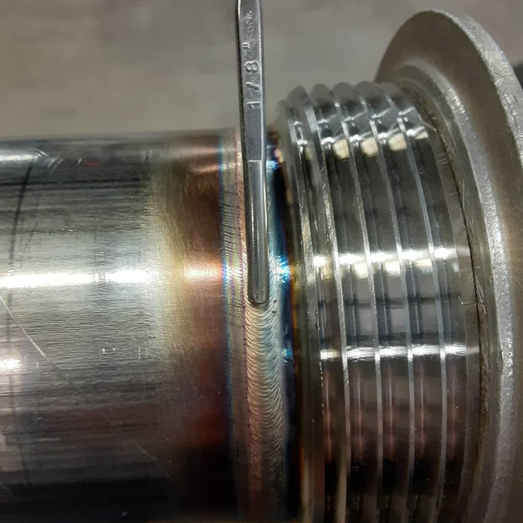 A close up of a metal pipe with a screw in it.