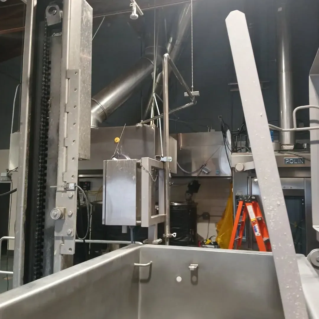 A stainless steel machine with a ladder in the background