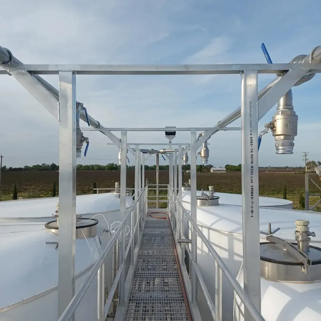 A walkway leading to a row of white tanks