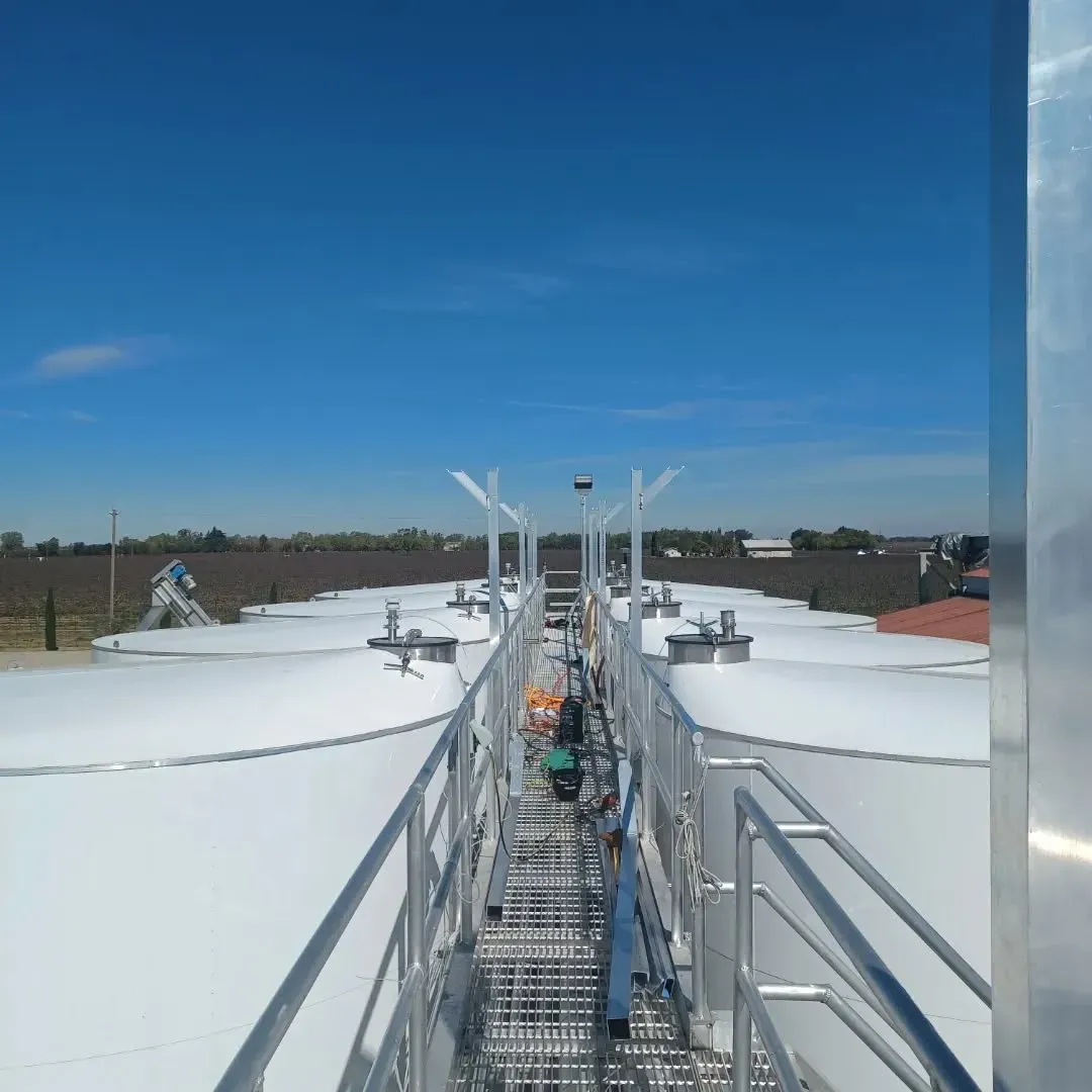 A row of white tanks with a blue sky in the background
