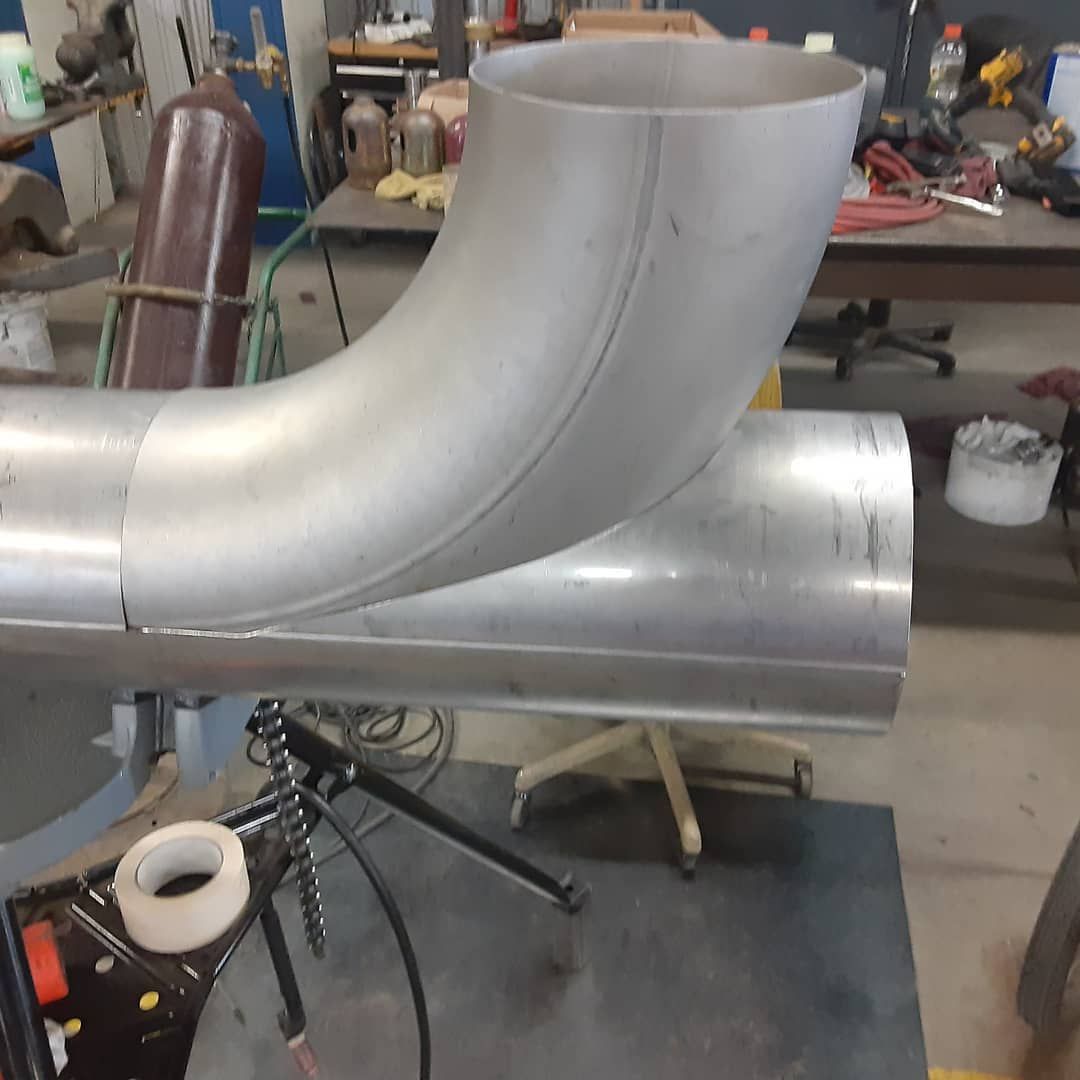 A metal pipe is sitting on a table in a workshop