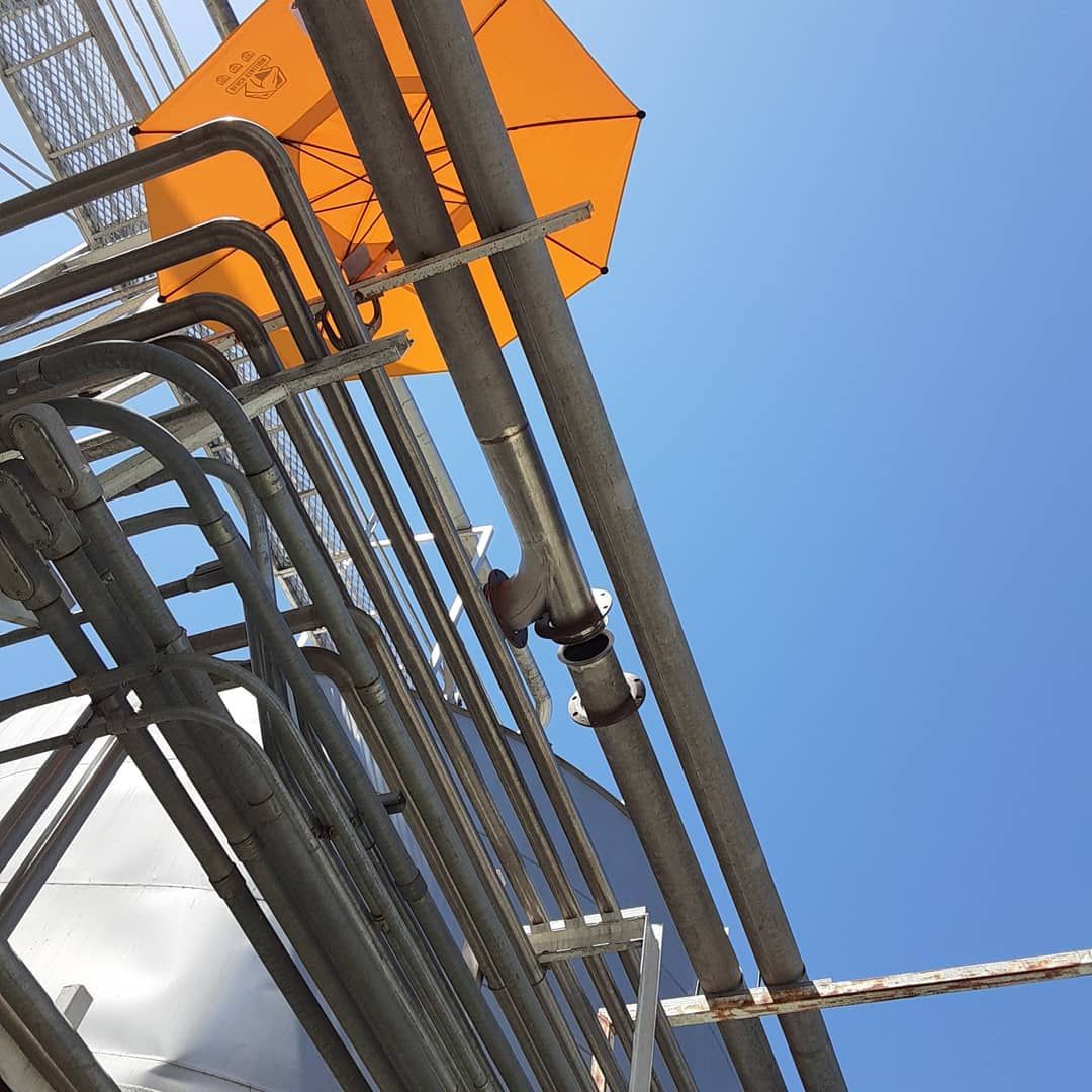A yellow umbrella is hanging from the side of a building