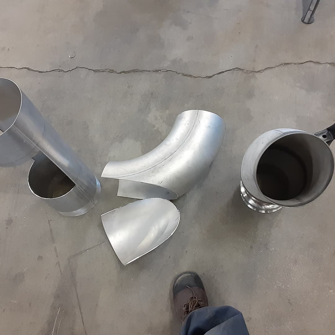 A person standing next to a bunch of metal pipes