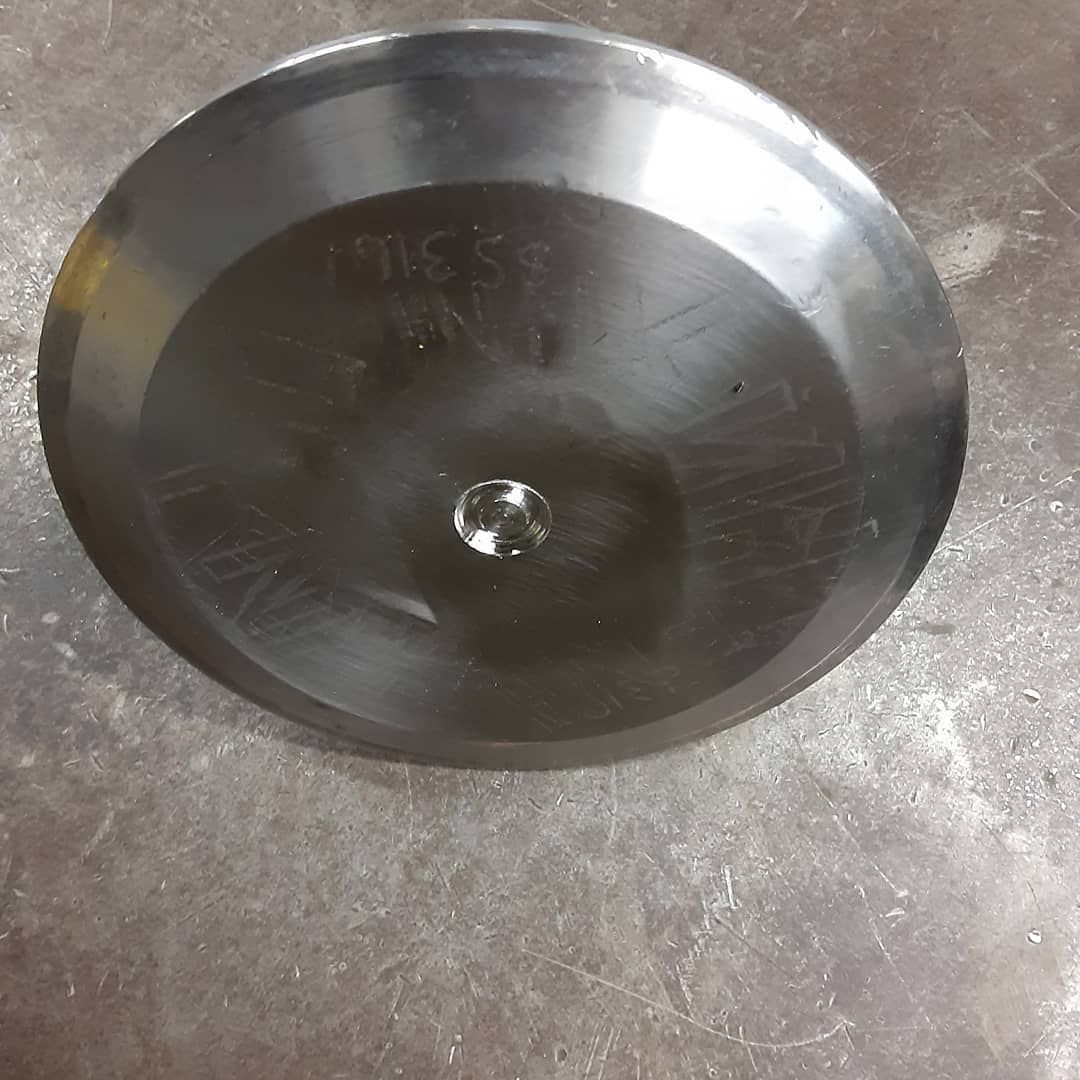 A black bowl with a hole in the middle is sitting on a table.