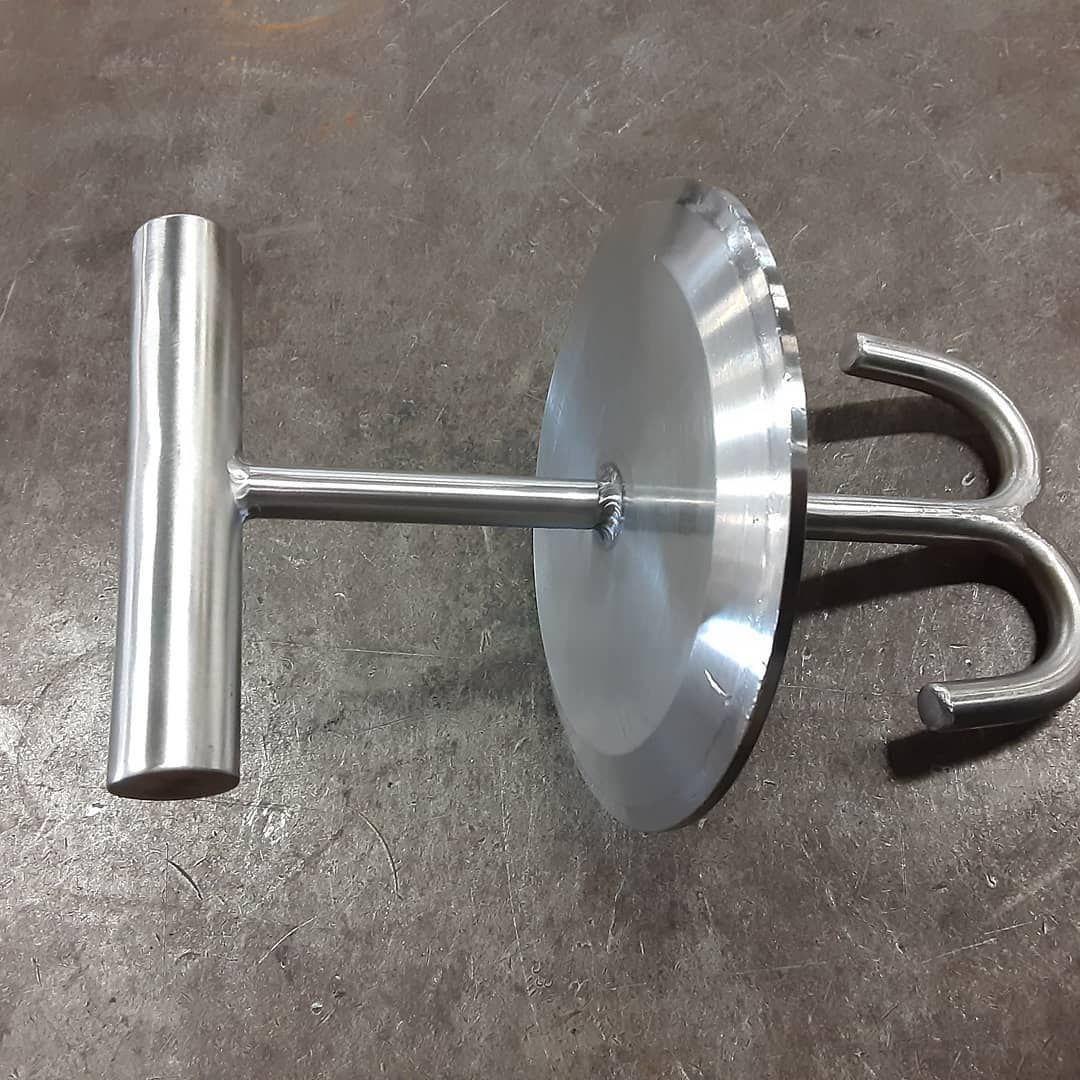 A metal object with a hook on it is sitting on a table.