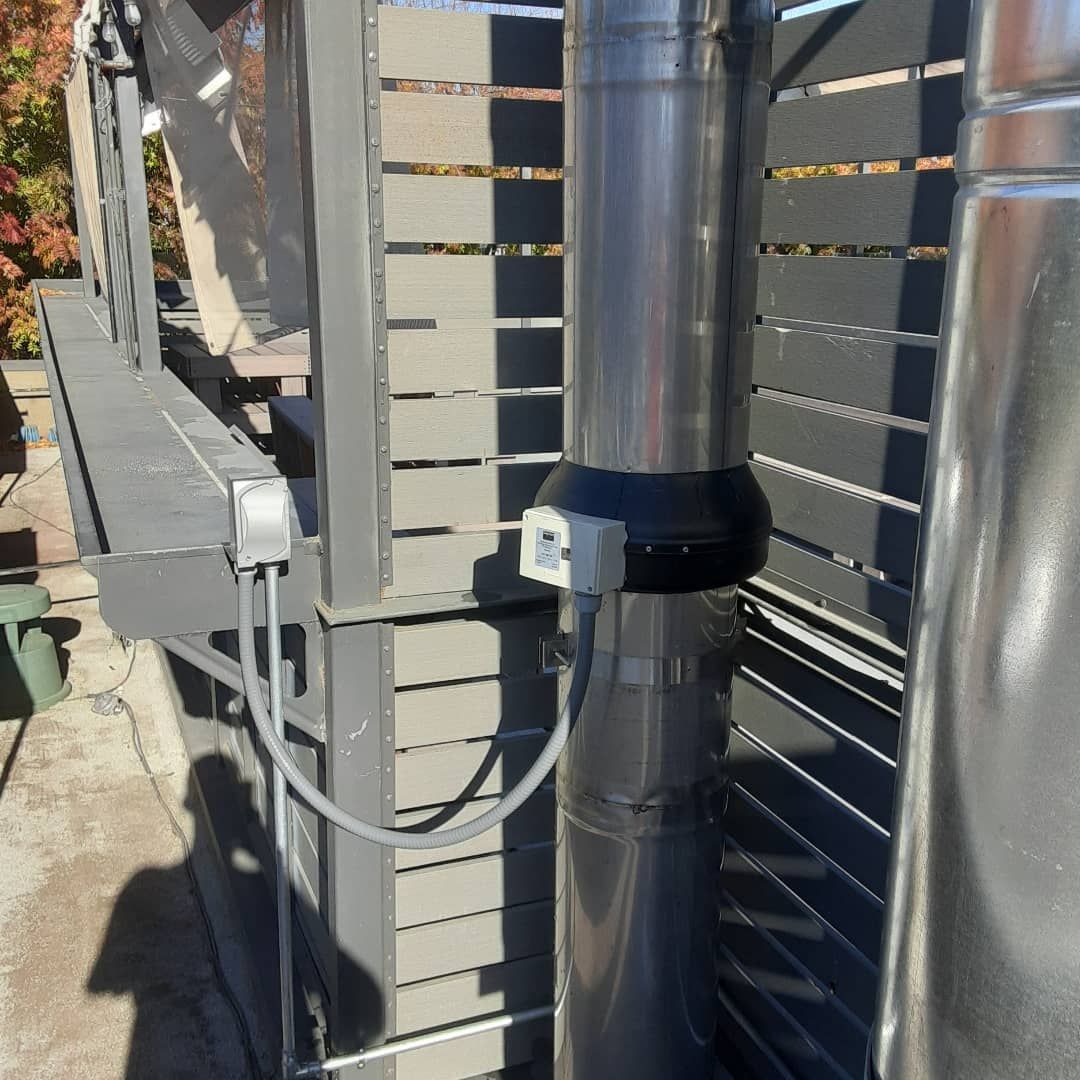 A stainless steel pipe is attached to a wooden fence.