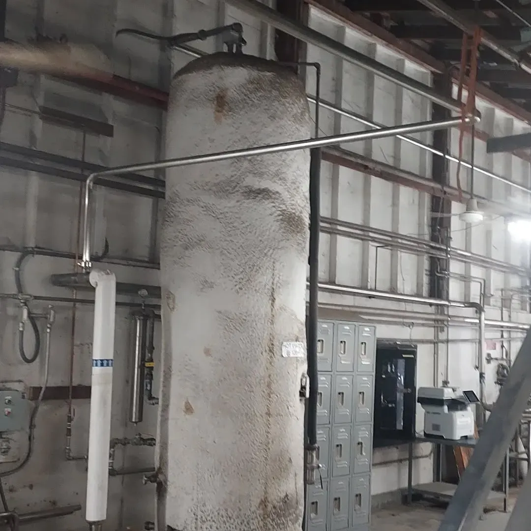 A large white tank is in a room with pipes