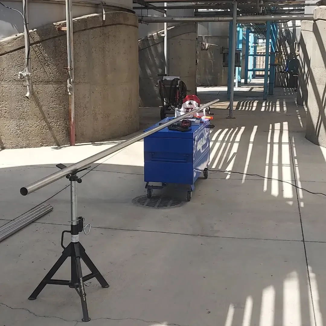 A tripod is sitting on the ground next to a blue box.