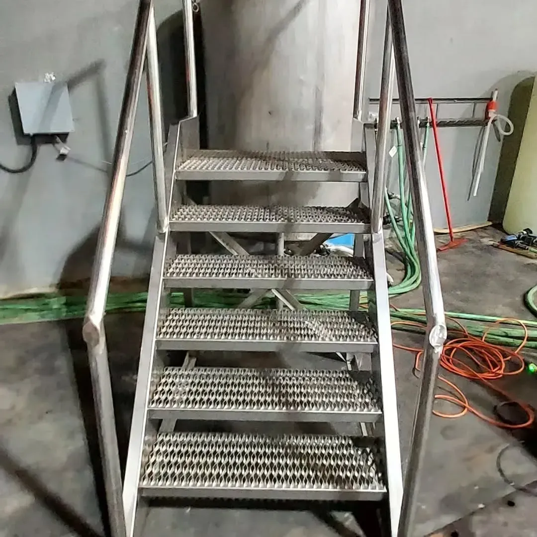 A set of stairs leading up to a stainless steel tank.