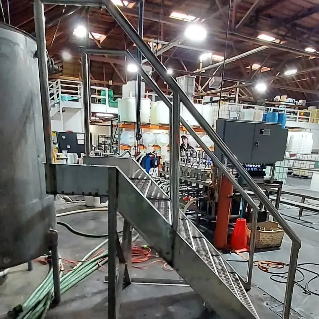 A staircase leading up to a large tank in a factory.