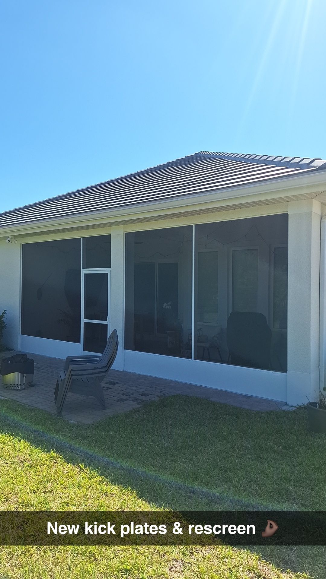 Screened-in porch with new kick plates and rescreening against a bright blue sky. Green grass in foreground.