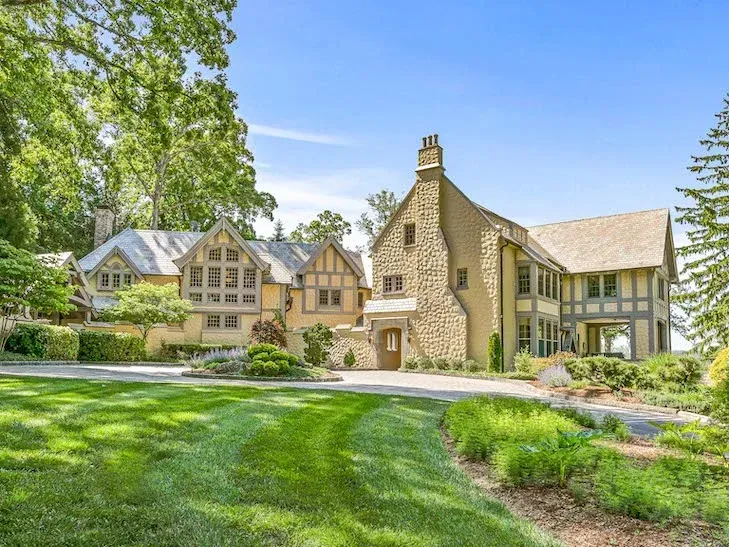 A large house with a lush green lawn in front of it.
