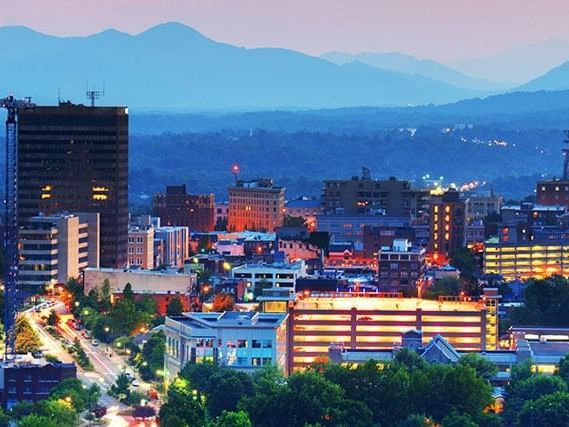 An aerial view of a city at night with mountains in the background