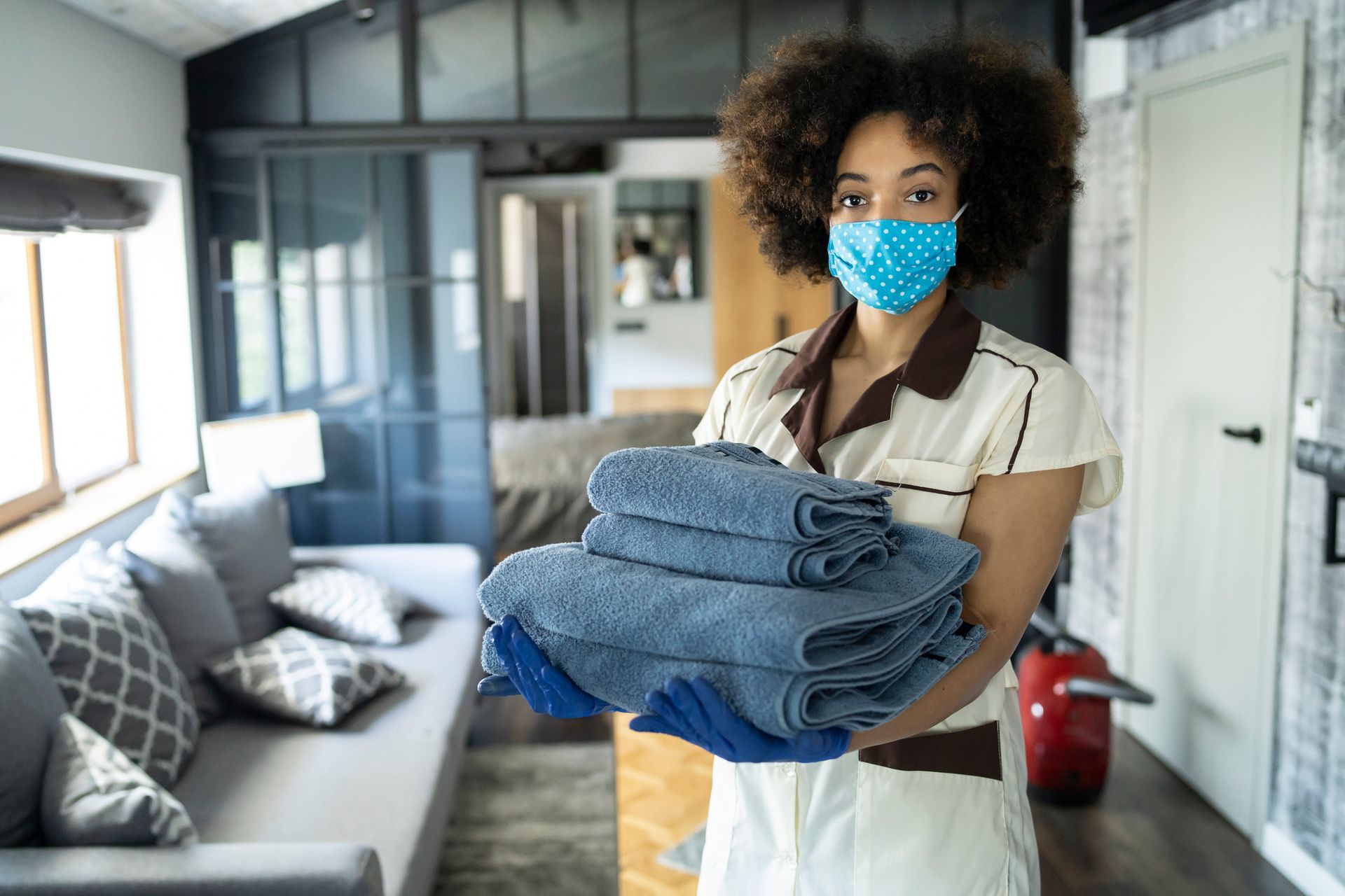 Hotel housekeeper providing towels to hotel room
