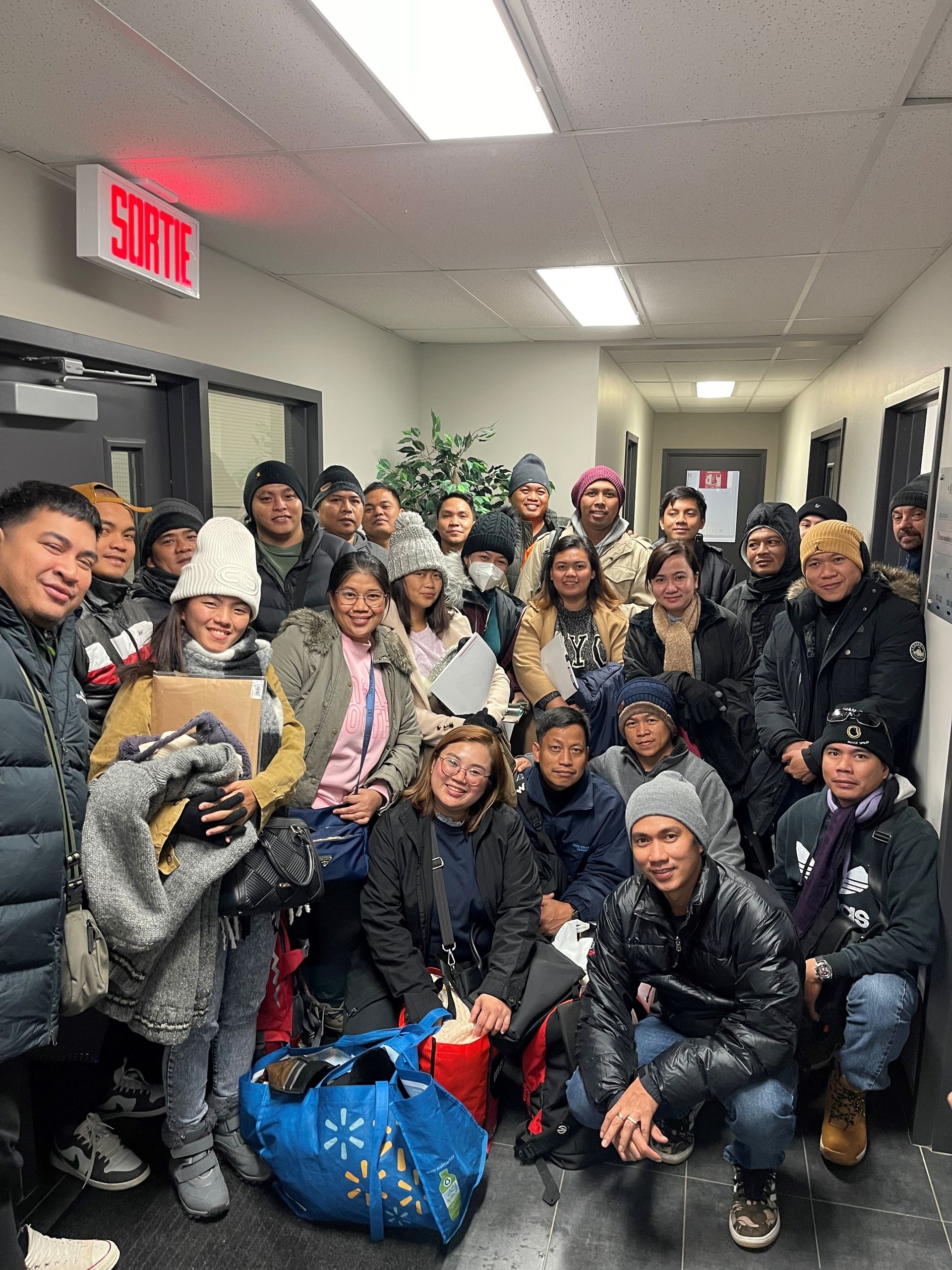 Un groupe de personnes pose pour une photo dans un couloir.