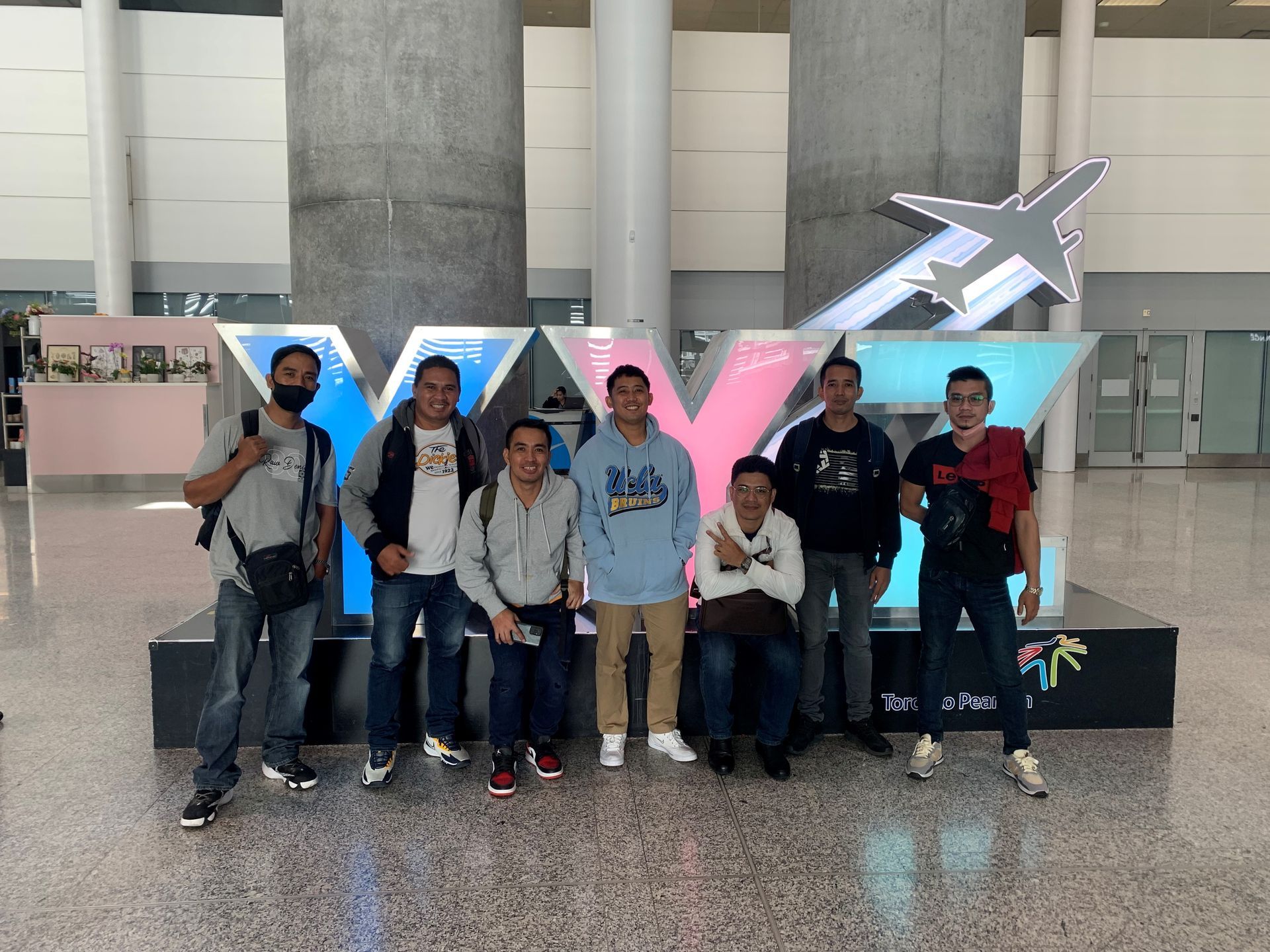 Un groupe d'hommes pose pour une photo devant un panneau indiquant xyz