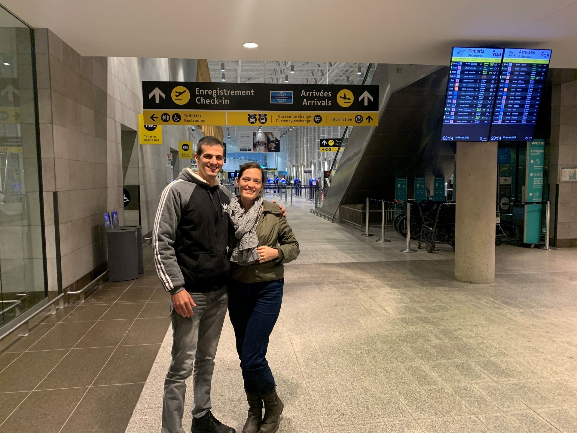 Un homme et une femme se tiennent côte à côte dans un aéroport.