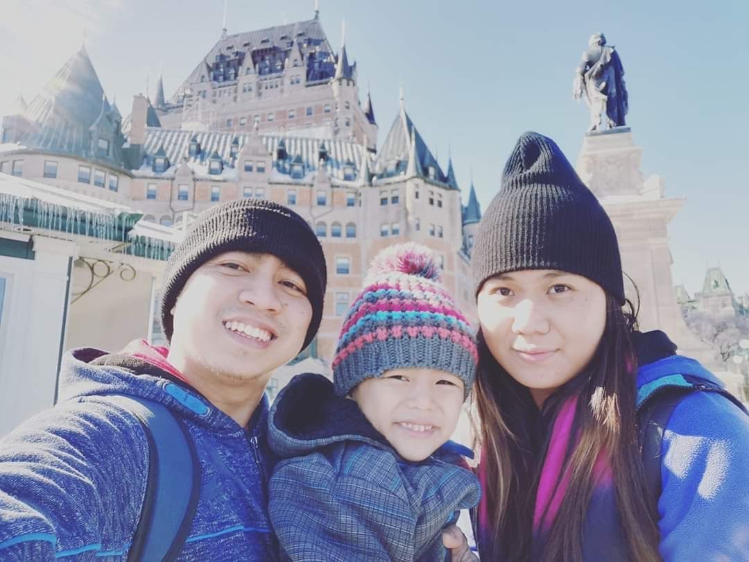Une famille pose pour une photo devant un château.