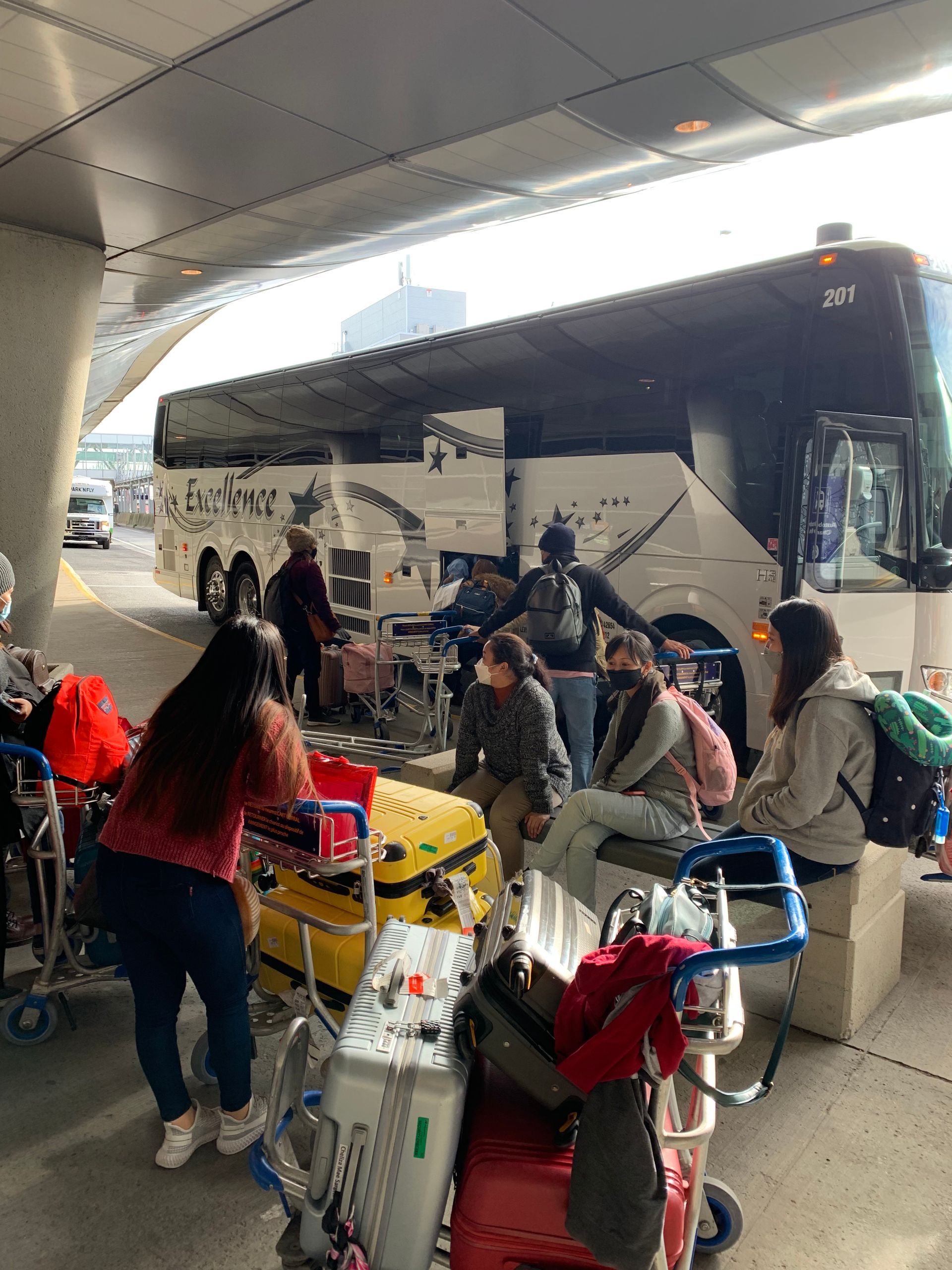 Un groupe de personnes attend un bus dans un aéroport.