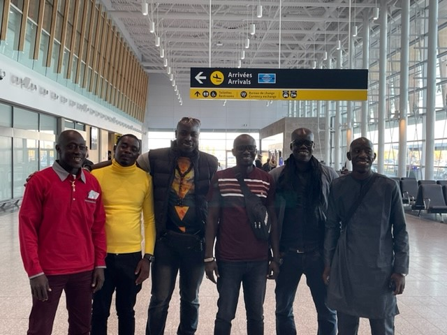 Un groupe d'hommes pose pour une photo dans un aéroport