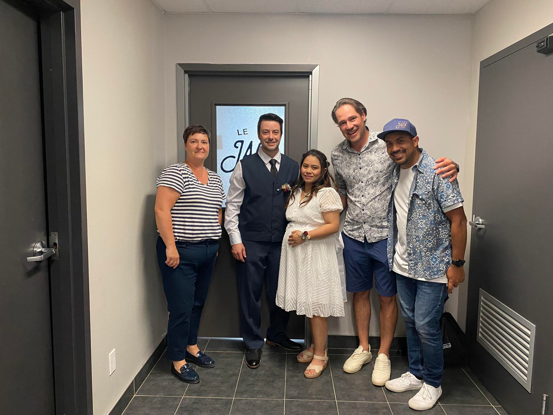 Un groupe de personnes pose pour une photo dans un couloir.