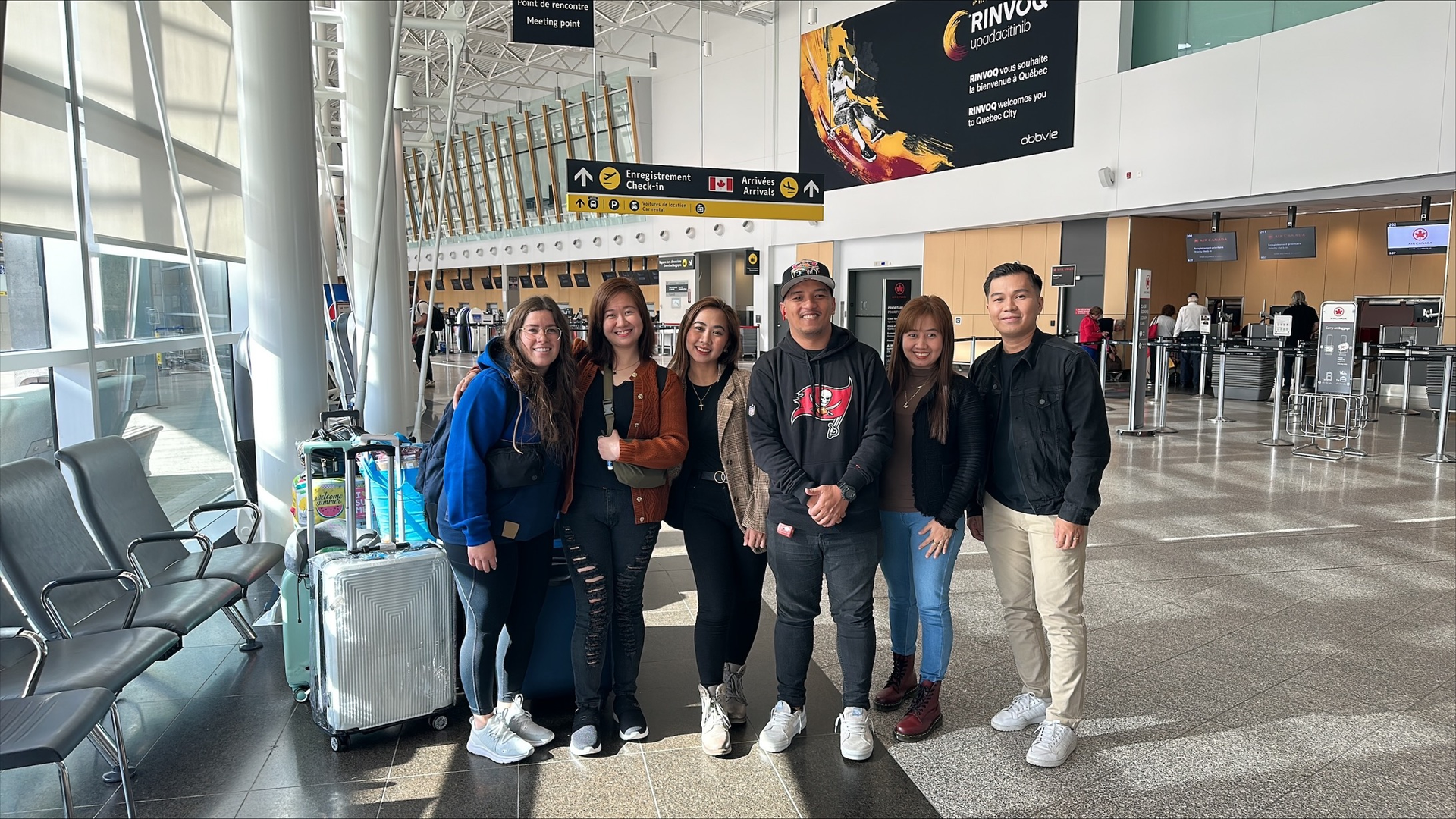 Un groupe de personnes pose pour une photo dans un aéroport.